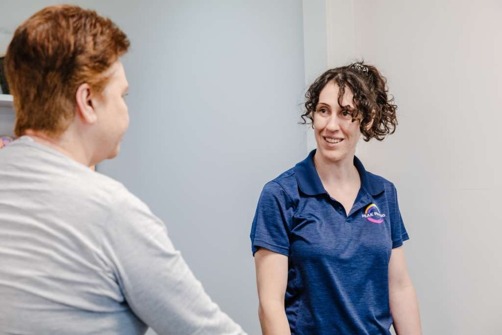 physiotherapist working with a client in their home